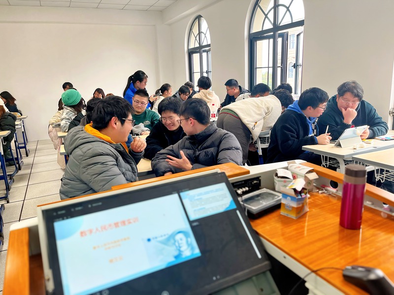 桌子上放着笔记本电脑的一群人  描述已自动生成